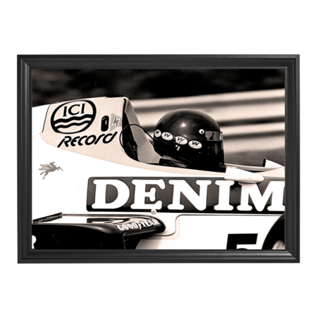 Framed black-and-white photo of a 1980s Formula 1 driver in a car with “DENIM” livery.