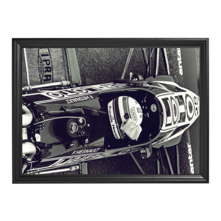Framed black-and-white photo of a Ligier Formula 1 driver sitting in cockpit.