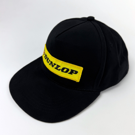 Black vintage cap with yellow Dunlop patch on front.
