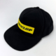 Black vintage cap with yellow Dunlop patch on front.
